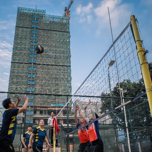 在深圳市光明区石介头村，村民们正在开展排球比赛，背后的光明天安云谷正在有序地施工。.jpg